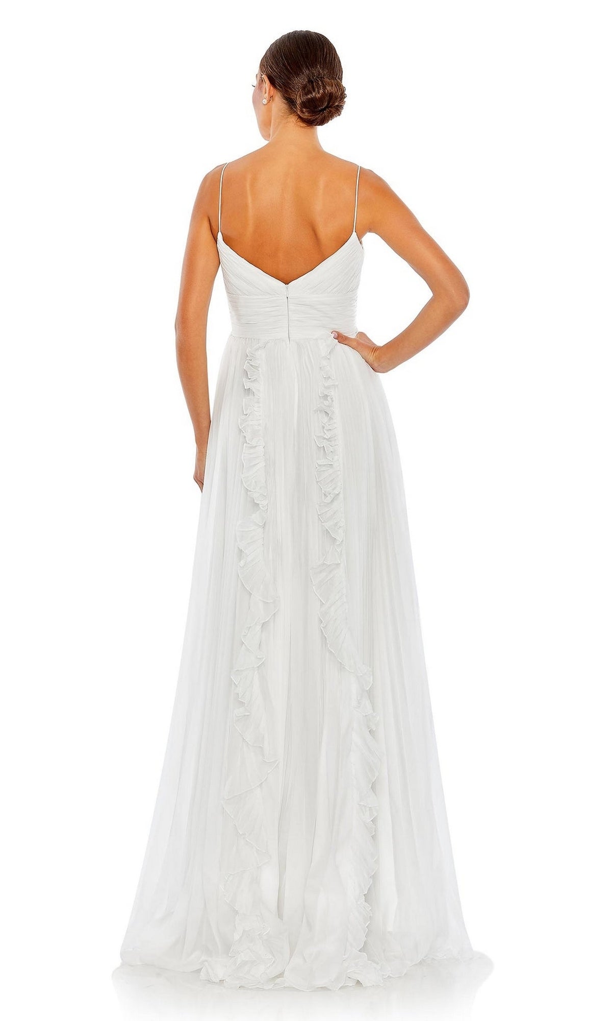 A woman stands with her back to the camera in the Ruffled Long White Formal Dress 49533, featuring thin straps, ruffle details down the back, and a neat bun for an elegant, A-line evening gown look.